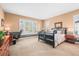 Bright bedroom featuring large windows with shutters, a comfortable bed, and dedicated workspace with elegant trim accents at 7035 S Picadilly St, Aurora, CO 80016