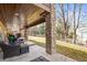 Covered patio with stone pillars, comfortable wicker furniture, and a serene backyard view at 7035 S Picadilly St, Aurora, CO 80016