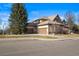 Exterior of a house featuring multiple garage doors, well-kept lawn, and mature trees at 7035 S Picadilly St, Aurora, CO 80016