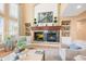 Cozy living room featuring built-in shelving, a stone fireplace, and large windows at 7035 S Picadilly St, Aurora, CO 80016