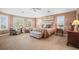 Spacious main bedroom with tray ceiling, large windows, and a sitting area filled with natural light at 7035 S Picadilly St, Aurora, CO 80016