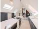 Bright kitchen with a large island, quartz countertops, pendant lighting, skylights, and stainless steel appliances at 1165 N Pennsylvania St # 3B, Denver, CO 80203