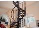 Close-up of the spiral staircase with decorative ironwork and natural light streaming through the nearby window at 1165 N Pennsylvania St # 3B, Denver, CO 80203