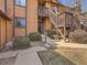 Exterior view of a tan home with wood siding, landscaped pathway, and entrance stairs to a unit at 9477 W 89Th Cir, Broomfield, CO 80021