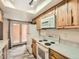 White appliances and countertops in a bright kitchen with wood-look flooring and patio access at 9477 W 89Th Cir, Broomfield, CO 80021