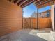An enclosed patio with stained wood walls, wooden fencing, and a concrete floor under a covered roof at 9477 W 89Th Cir, Broomfield, CO 80021