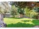 Serene backyard featuring lush lawn, mature trees, a storage shed, and a privacy fence at 6120 W 111Th Ave, Westminster, CO 80020