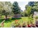 Well-maintained backyard featuring lush green lawn, mature trees, and colorful flower beds at 6120 W 111Th Ave, Westminster, CO 80020
