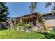 Backyard patio with pergola covered in lush greenery, steps leading to lawn at 6120 W 111Th Ave, Westminster, CO 80020