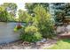 Landscaped garden bed with decorative rocks, lush plants, and a hanging flower basket at 6120 W 111Th Ave, Westminster, CO 80020
