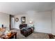 Cozy living room with plush armchair, warm lighting, and view into kitchen, creating an inviting space at 6120 W 111Th Ave, Westminster, CO 80020