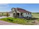 Charming two-story home features a stone-accented porch, attached garage, and lush green landscaping with a sprawling lawn at 28340 Dylon Cir, Elizabeth, CO 80107