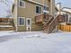 Wooden deck and stairs leading to a snow-covered backyard at 1218 Ascot Ave, Highlands Ranch, CO 80126