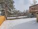 Snow covered backyard with wooden deck and fence at 1218 Ascot Ave, Highlands Ranch, CO 80126