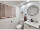 Powder room with floating vanity and circular mirror at 1218 Ascot Ave, Highlands Ranch, CO 80126