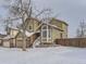 Two-story house with a snow covered lawn and attached two-car garage at 1218 Ascot Ave, Highlands Ranch, CO 80126