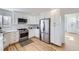 Modern kitchen with white cabinets, stainless steel appliances, and light wood floors at 1218 Ascot Ave, Highlands Ranch, CO 80126