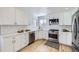 Modern kitchen featuring white shaker cabinets, stainless steel appliances, and light wood floors at 1218 Ascot Ave, Highlands Ranch, CO 80126