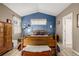 Bright bedroom featuring a wooden bed, blue accent wall, and light wood flooring at 13263 Niwot Trl, Broomfield, CO 80020
