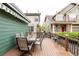 Deck features a dining table, seating, lovely plants, and an awning, situated between neighboring houses and manicured lawns at 13263 Niwot Trl, Broomfield, CO 80020
