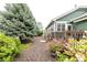 A beautifully landscaped yard with mature trees and flowering plants surrounds a home with a charming deck and cozy outdoor space at 13263 Niwot Trl, Broomfield, CO 80020