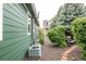 Green house exterior showcases a well-maintained yard with a charming bench and a blend of greenery, trees, and plants at 13263 Niwot Trl, Broomfield, CO 80020