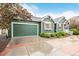 Attached two-car garage with a green door and a well-manicured front yard with mature landscaping at 13263 Niwot Trl, Broomfield, CO 80020