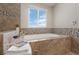 Relaxing bathroom with soaking tub and a bright window at 6858 Johnson St, Arvada, CO 80004