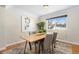 Bright dining room features hardwood floors, a rustic wood table, and four gray chairs at 6858 Johnson St, Arvada, CO 80004