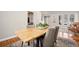 A second view of the dining room with a rustic wood table and four gray chairs at 6858 Johnson St, Arvada, CO 80004