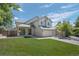 Two-story house with attached garage and manicured lawn at 6858 Johnson St, Arvada, CO 80004