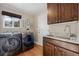 Laundry room with modern washer and dryer and utility sink at 6858 Johnson St, Arvada, CO 80004