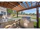 Pergola-covered outdoor kitchen with grill at 6858 Johnson St, Arvada, CO 80004