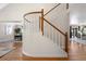 View of a curved staircase with white spindles and wooden handrail at 6858 Johnson St, Arvada, CO 80004