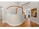 Elegant curved staircase with wooden railing and hardwood floors at 6858 Johnson St, Arvada, CO 80004