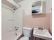 Bathroom featuring a shower, sink, and toilet with pink tile and white accents at 2675 N Saint Paul St, Denver, CO 80205