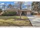 Charming brick home featuring a well-manicured lawn and a long, paved driveway leading to an attached garage at 2675 N Saint Paul St, Denver, CO 80205