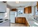 Cozy kitchen features wood cabinets, white appliances, and a window with a view at 2675 N Saint Paul St, Denver, CO 80205