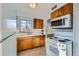 Bright kitchen with wooden cabinets, white appliances, and a view from the window at 2675 N Saint Paul St, Denver, CO 80205