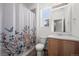 Bathroom with floral shower curtain, wood-look floors, and a window at 5319 Warrior St, Frederick, CO 80504