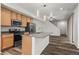 Modern kitchen with stainless appliances, wood cabinets, eat-in island and seamless flow to the dining area at 5319 Warrior St, Frederick, CO 80504