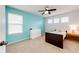Bedroom featuring plush carpet, blue accent wall, a ceiling fan, and white trim at 22962 Briar Leaf Ave, Parker, CO 80138