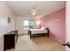 A bedroom featuring white trim, plush carpet, and a pastel pink accent wall at 22962 Briar Leaf Ave, Parker, CO 80138