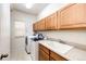 Functional laundry room with modern appliances, ample cabinet space, a utility sink, and tile floors at 22962 Briar Leaf Ave, Parker, CO 80138
