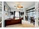 Well-lit office with large desk, built-in shelves, neutral carpet, and elegant French doors at 22962 Briar Leaf Ave, Parker, CO 80138