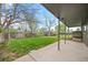View of the backyard with a covered patio, green lawn, and partial fencing at 1000 Zang St, Golden, CO 80401