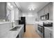 Open kitchen layout with stainless steel appliances, white subway tile backsplash, and wood-look floors at 1000 Zang St, Golden, CO 80401