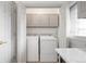 Functional laundry room with washer, dryer, and overhead cabinets for storage at 1000 Zang St, Golden, CO 80401