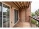 Private balcony with brick accent wall, tan door, and sliding glass doors overlooking a parking area at 4899 S Dudley St # 15B, Littleton, CO 80123