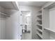 Bright closet adjacent to bathroom with grey vinyl floors and shelving for optimal storage at 4899 S Dudley St # 15B, Littleton, CO 80123